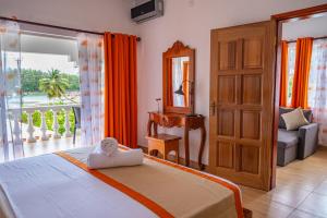 een slaapkamer met een bed en een glazen schuifdeur bij Athara's Apartment in Anse Possession