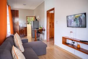 a living room with a couch and a tv at Athara's Apartment in Anse Possession