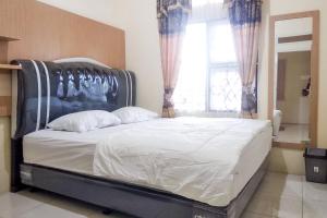 1 cama grande en un dormitorio con ventana grande en Griya De Riz Syariah Mitra RedDoorz en Jambi