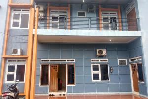 um edifício azul com uma varanda em cima em Griya De Riz Syariah Mitra RedDoorz em Jambi