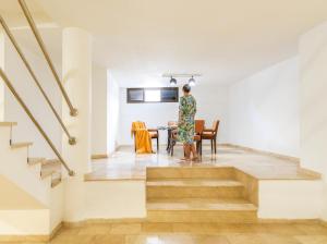 a woman standing in a living room next to a table at Villas Las Almenas in Maspalomas