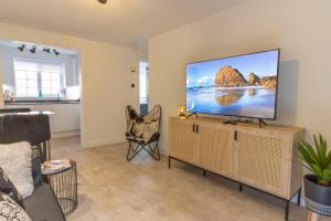 a living room with a large flat screen tv at Spacious City Centre Apt Near Cathedral in Exeter