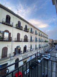 a large white building with cars parked in a parking lot at 55 Aira Hotel in Palermo