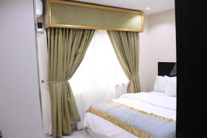 a bedroom with a bed and a window at Appleville Suites in Ikeja