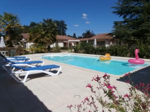 a swimming pool with two lounge chairs and a toy flamingo at Chambres d'Hôtes Bien Être 47 in Sos