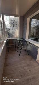 Habitación con balcón con mesa y sillas. en Квартира студия в центре Чернигова wi-fi en Chernihiv