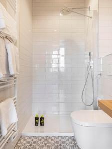 uma casa de banho branca com uma banheira e um chuveiro em limehome Bamberg Maximiliansplatz em Bamberg