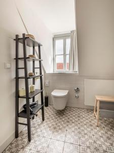 a bathroom with a toilet and a shelf at limehome Bamberg Maximiliansplatz in Bamberg