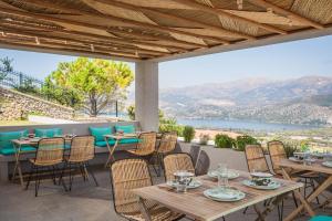 a patio with tables and chairs and a view of a lake at Harmony Suites in Khelmáta