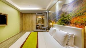 a hotel room with a bed and a painting on the wall at Vyluk Hotel Yuncheng Salt Lake Nanfeng Plaza in Yuncheng