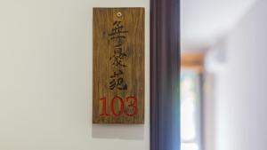 a wooden sign on a door with asian writing on it at Floral Hotel Jixian Heping Heyuan Jizhou Karst Cave Ares Valley in Ershilipu