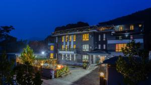 a large building at night with its lights on at Floral Hotel Jixian Heping Heyuan Jizhou Karst Cave Ares Valley in Ershilipu