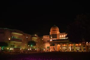 a large building with a clock tower at night at The River Front Resort in Sītāpur Mūāfi