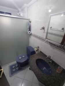 bagno con lavandino, servizi igienici e specchio di María Cristina ,ar,Wi-Fi e tv a cabo a Praia Grande
