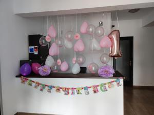 a bunch of pink and white balloons hanging from a wall at Pensiunea VisAventura in Vişan
