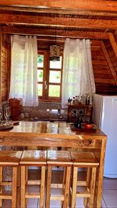 cocina con encimera de madera grande y nevera en Chalé do Portal en Monte Verde