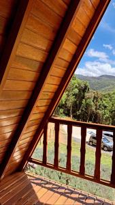 een uitzicht vanaf een houten terras met uitzicht op een veld bij Chalé do Portal in Monte Verde