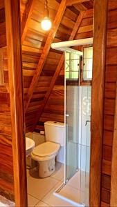 ein Badezimmer mit einem WC und einer Glasduschkabine in der Unterkunft Chalé do Portal in Monte Verde