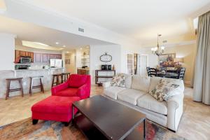 uma sala de estar com um sofá e uma cadeira vermelha em Phoenix West II em Orange Beach