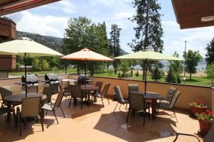 a patio with tables and chairs and umbrellas at Waterfront Inn in Penticton