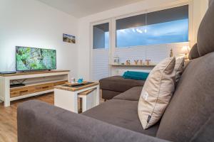 ein Wohnzimmer mit einem Sofa und einem TV in der Unterkunft Sylter Perle in Westerland