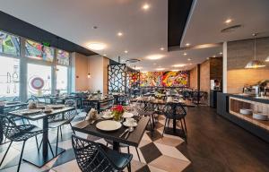 un restaurante con mesas y sillas en una habitación en Amarant Apart Hotel by CHM en Kiev