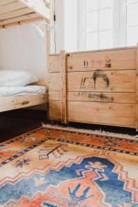 a bedroom with a bed and a rug at Jaca Hostel Porto da Cruz in Porto da Cruz