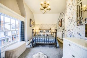 a bathroom with a crib and a chandelier at Penthouse On Waterside With River Views, Private Parking & Secluded Hot Tub in Stratford-upon-Avon