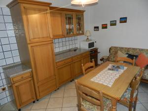 eine Küche mit einem Holztisch und einem Esszimmer in der Unterkunft Casa Brugnara in Pozza di Fassa