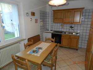 a kitchen with a wooden table and a table and chairs at Casa Brugnara in Pozza di Fassa