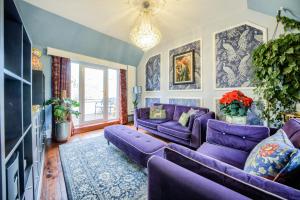 una sala de estar con muebles morados y un sofá púrpura. en Penthouse On Waterside With River Views, Private Parking & Secluded Hot Tub, en Stratford-upon-Avon