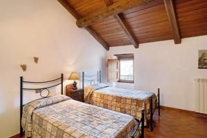 two beds in a room with wooden ceilings at La Casa della nonna in Vessalico +21 photos