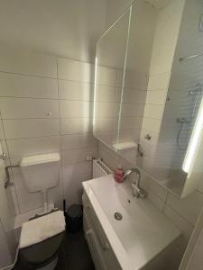 a bathroom with a sink and a toilet and a mirror at 1 Zimmer Wohnung in Strand nähe in Kiel