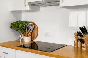 a kitchen counter with a vase of flowers on it at Surfside - Lennox Head in Lennox Head