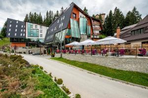 a building with tables and umbrellas next to a road at Hotel Blanca Resort & Spa in Vlasic