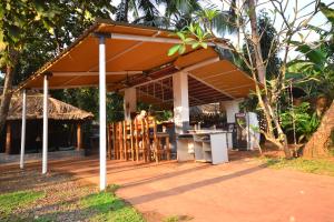 a pavilion with a table and chairs under it at Piccolo Dreams in Canacona