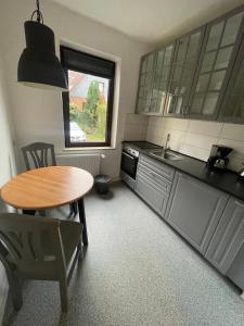 a kitchen with a table and a sink and a table at 1 Zimmer Wohnung in Strand nähe in Kiel