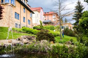 una persona caminando frente a un edificio con una fuente de agua en Luxury Spa & Wellness Vila Valaška, en Luhačovice