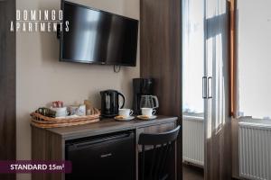 a kitchen with a table with a tv on the wall at DOMINGO Elegant Rooms KRAKÓW Old Town in Krakow
