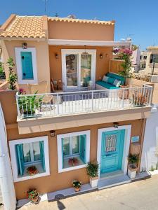 a house with blue doors and a balcony at MaVi House Old Town in Malia