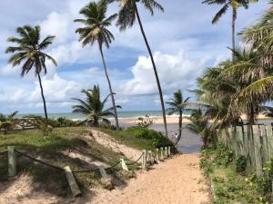 a path to the beach with palm trees at Residencial Ykutiba in Imbassai