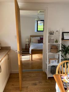 a room with a bedroom with a bed and a table at Cosy Cotswolds Self-Contained One Bedroom Cottage in Chipping Norton +19 photos