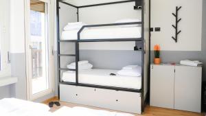 a room with a bunk bed with white pillows at Hotello Trieste in Trieste