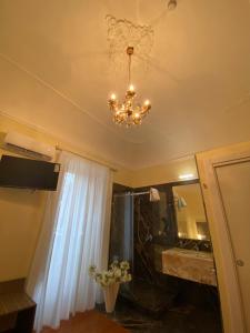 a bathroom with a chandelier on the ceiling at 55 Aira Hotel in Palermo