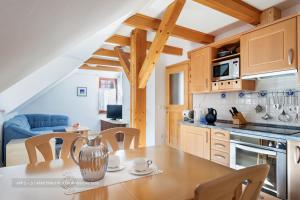 a kitchen and dining room with a table and chairs at Apartmaji Potepuh in Kranjska Gora