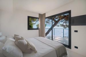 a bedroom with a bed and a large window at Villa Vista Mare by iVillamia com in Villefranche-sur-Mer +26 photos