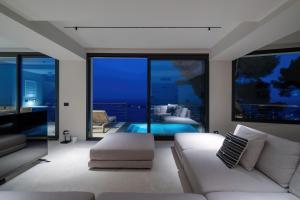 a living room with a couch and a swimming pool at Villa Vista Mare by iVillamia com in Villefranche-sur-Mer