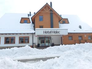 霍茨科波霍尔耶Pohorje Village Wellbeing Resort - Forest Hotel Videc的前面有大雪的建筑