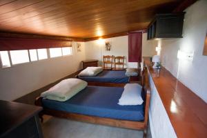 two beds in a room with wooden ceilings at Eco Finca in Paradise Valley Azuaje in Firgas