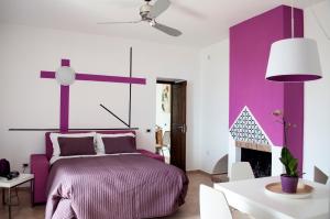 维耶特里泽扎尔公寓的一间卧室配有一张紫色的床和一个壁炉